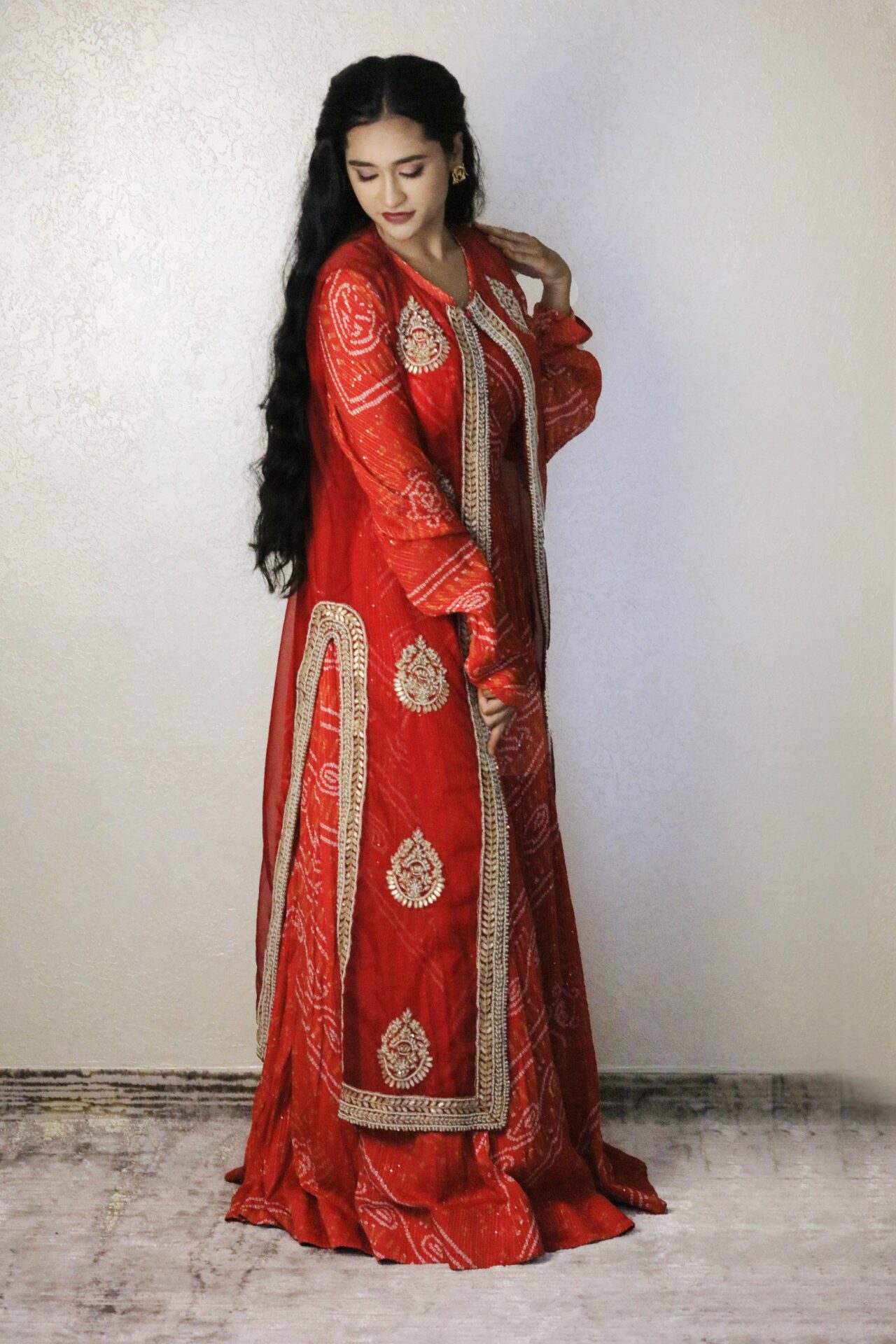 orange bandhani gown with contrast red jacket
