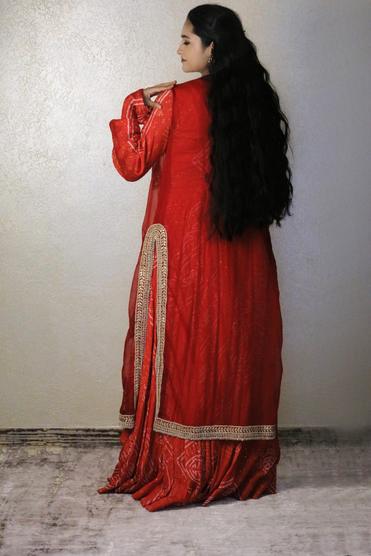 orange bandhani gown with contrast red jacket