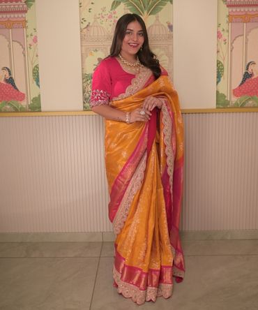Banarasi silk saree in mustard yellow with a contrasting hot pink embroidered border