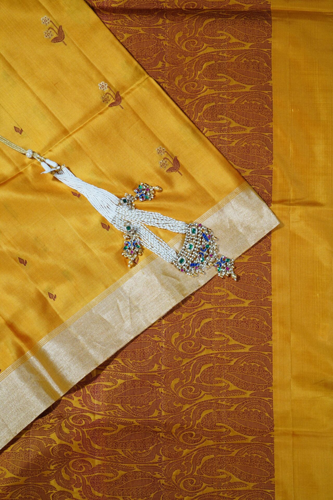 Soft silk saree with zari border and resham butis and resham pallu in mustard yellow.